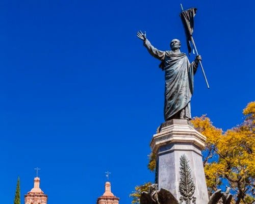Monumento a Hidalgo con la parroquia de Dolores de fondo