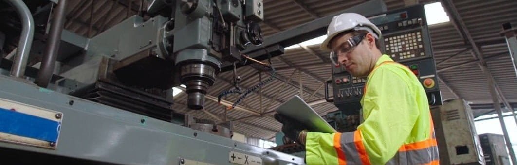 Trabajador supervisando un proceso de mecanizado mientras utiliza su equipo de protección personal