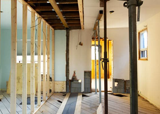 Apuntalamientos verticales metálicos y de madera dentro de una casa